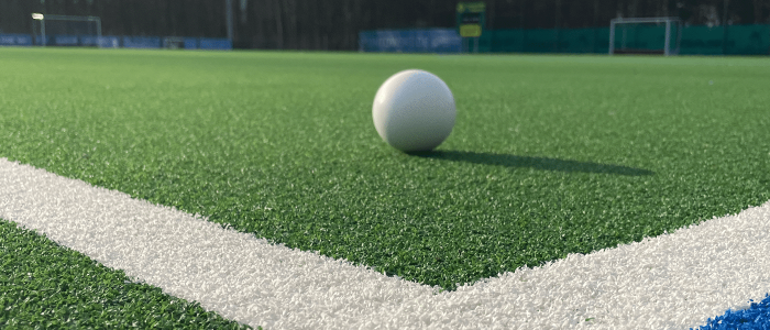 Hockey ball in a corner of the playground with perspective to the goal